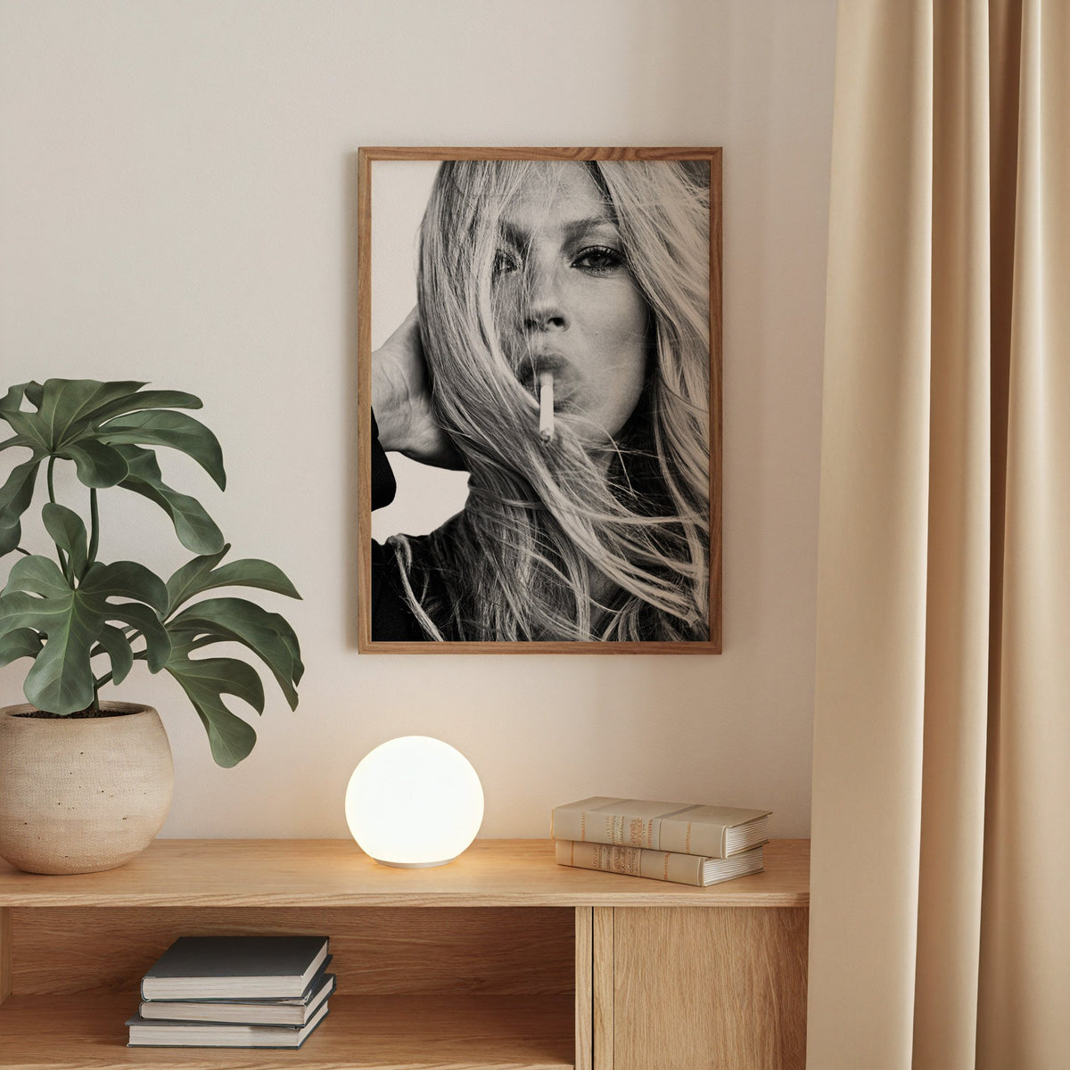 Woman with windswept hair across her face print in a walnut frame above an oak cabinet with a glowing globe lamp