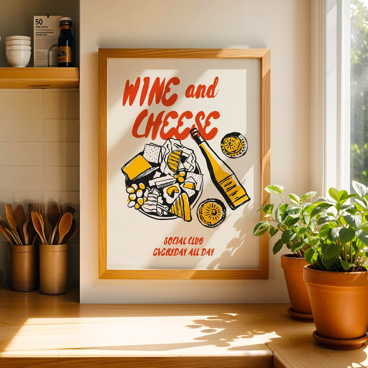 Cheese board print in a light wood frame on a butcher block counter by crocks of wooden utensils