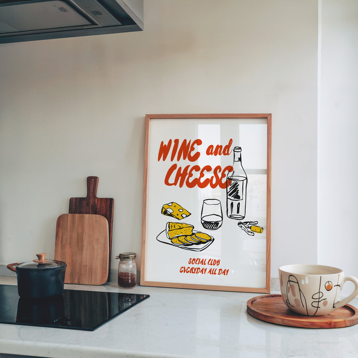 Wine and Cheese bottle print in a light pine frame leaning on a marble kitchen counter