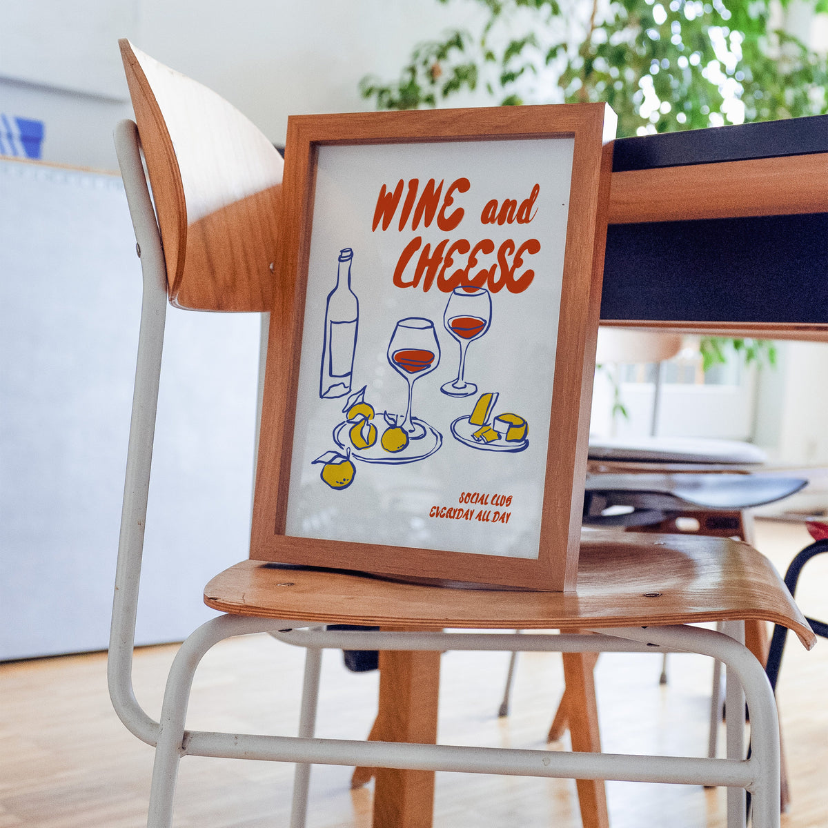 Wine and Cheese lemons print in a walnut frame on a bentwood chair