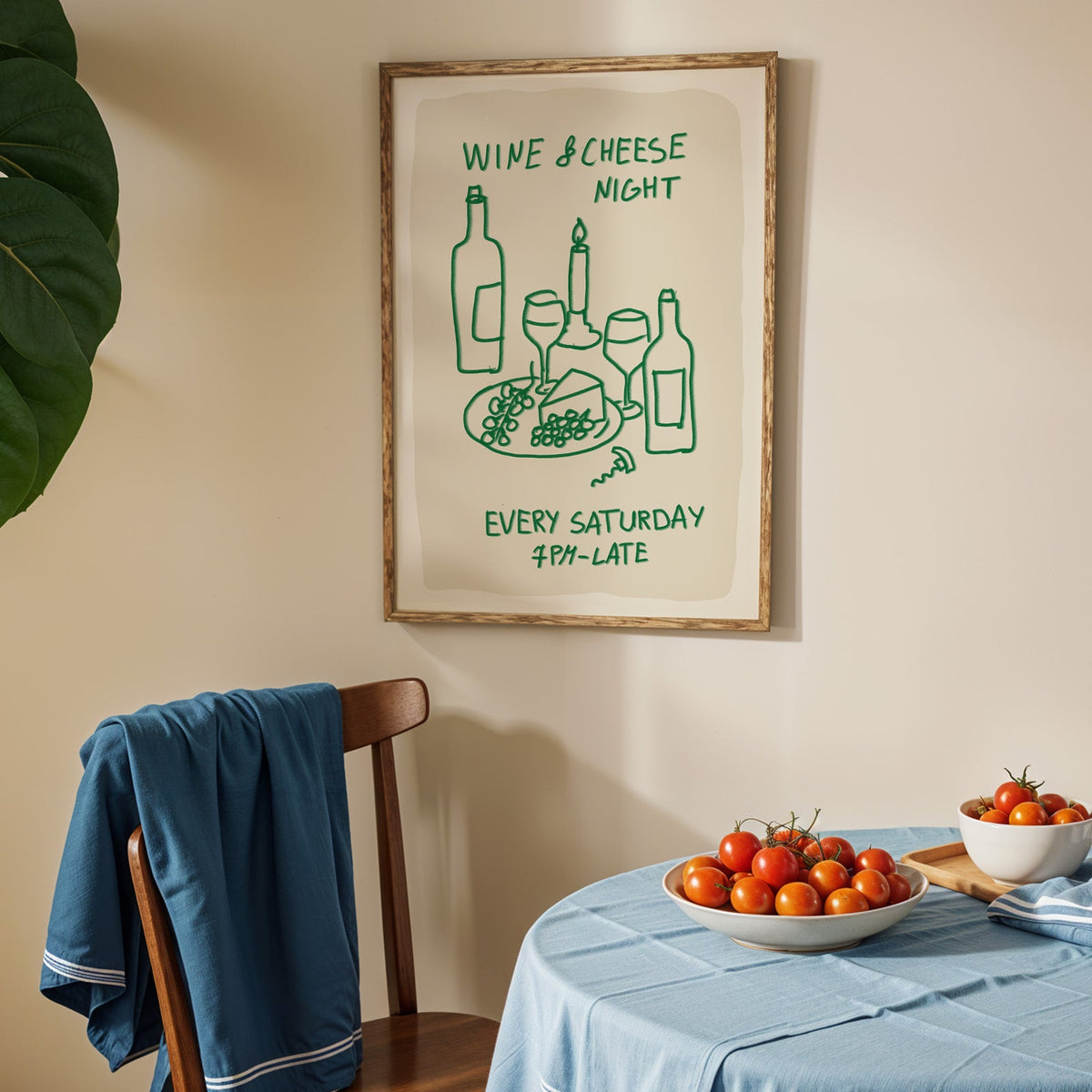 Wine and cheese night print in an oak frame above a blue linen table with tomatoes