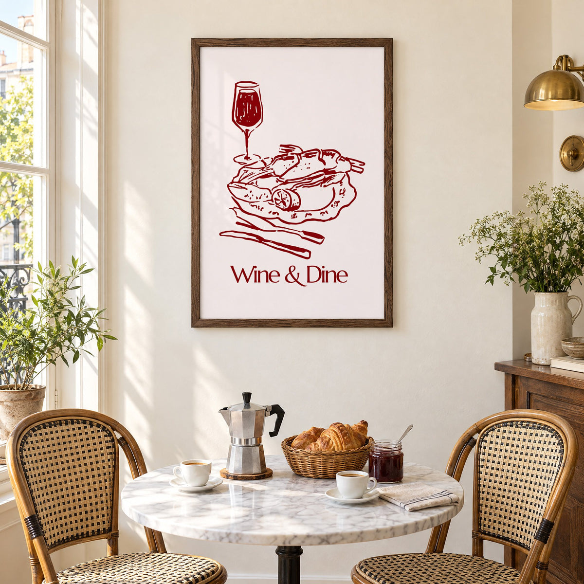 Wine & Dine roast plate burgundy sketch print in a walnut frame above a marble bistro table with croissants and rattan chairs