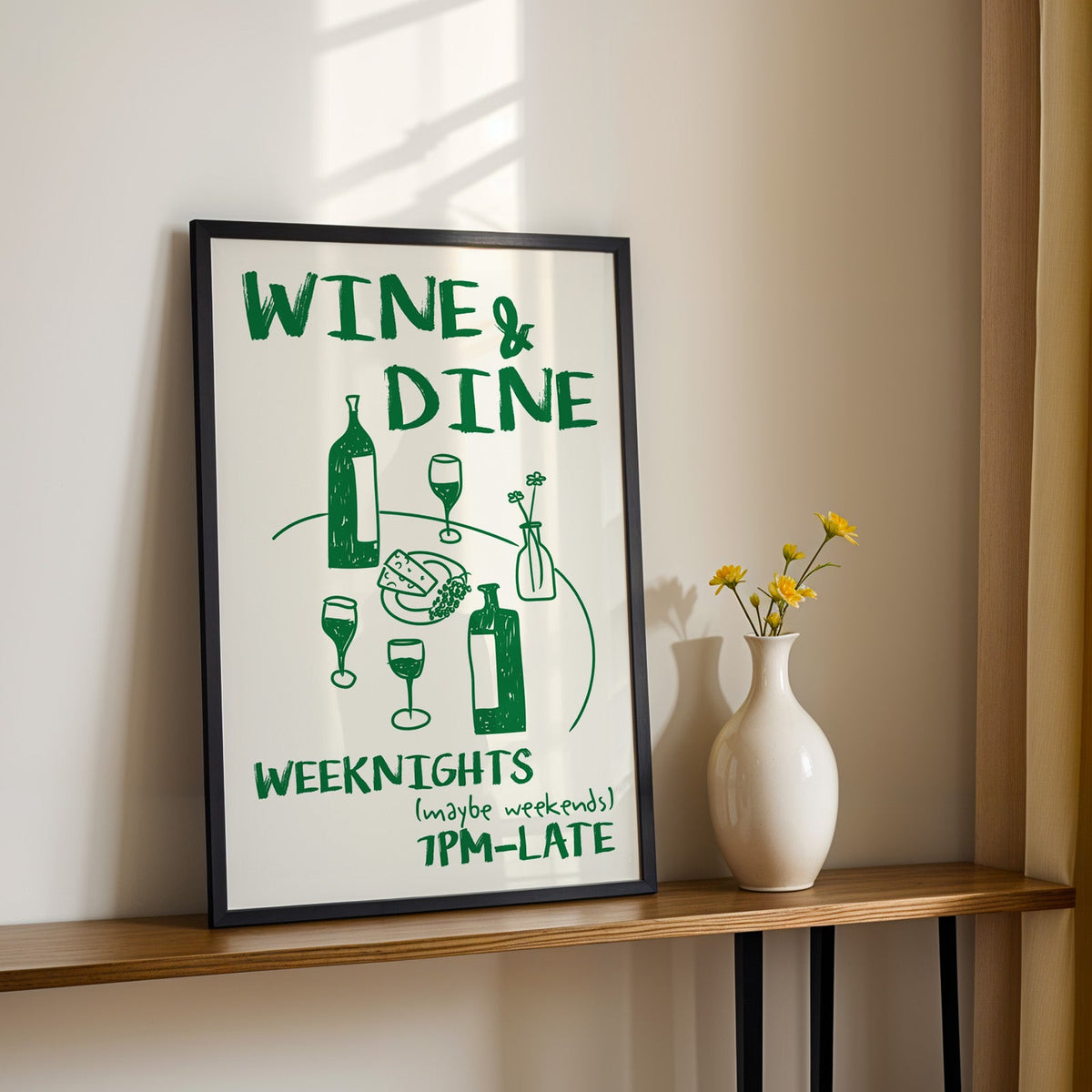 Wine and dine table print in a black frame on a console table with daisies