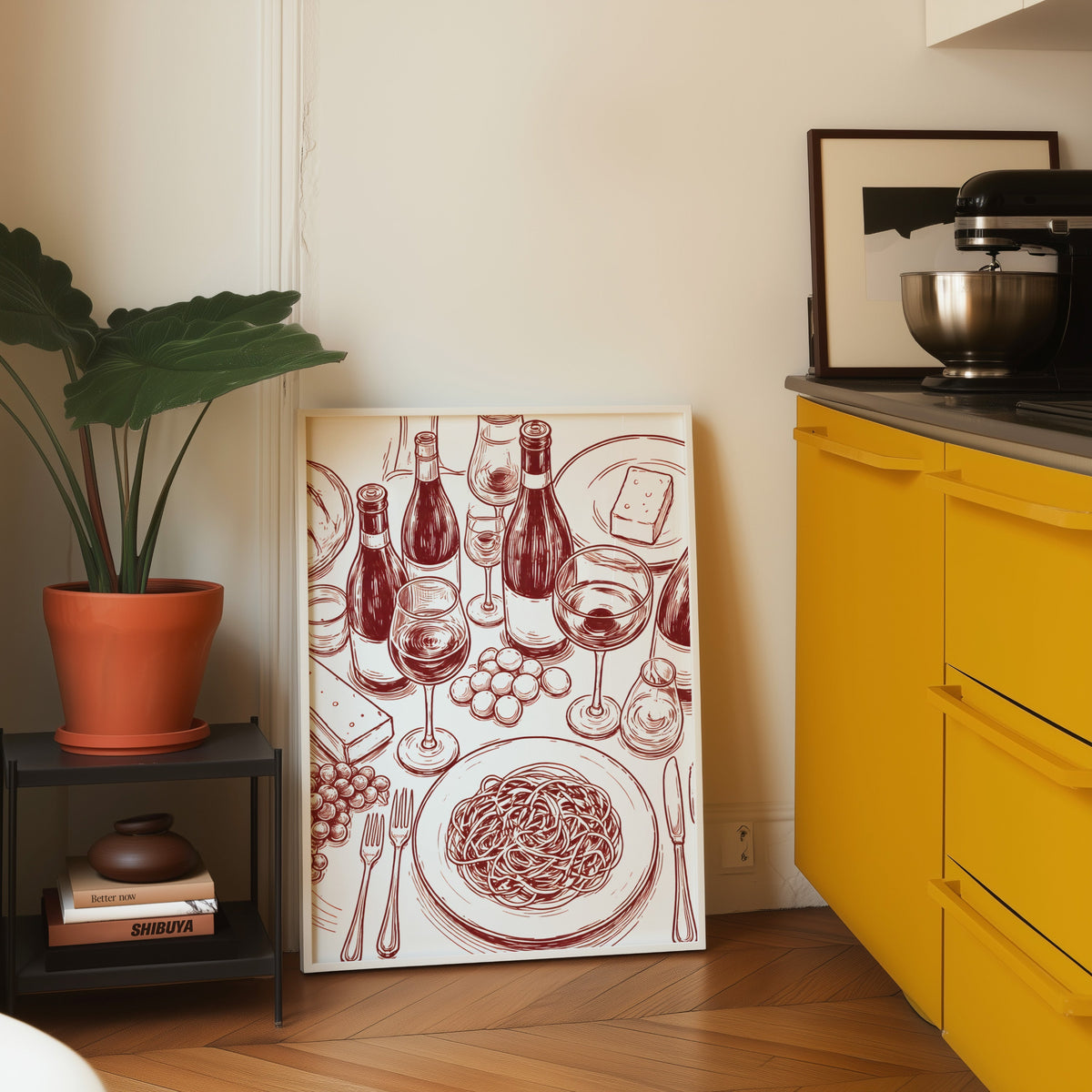 Wine and pasta print in a white frame leaning on parquet beside a bright yellow kitchen