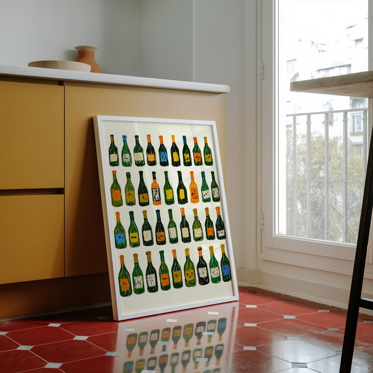 Wine bottle grid print in a white frame against yellow cabinets on red tiles