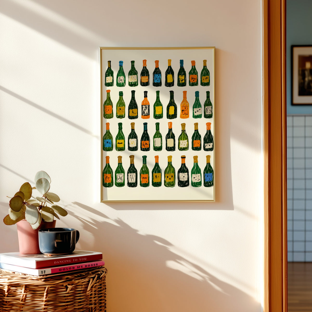 Wine bottle grid print in a gold frame above a basket of books and a pilea plant