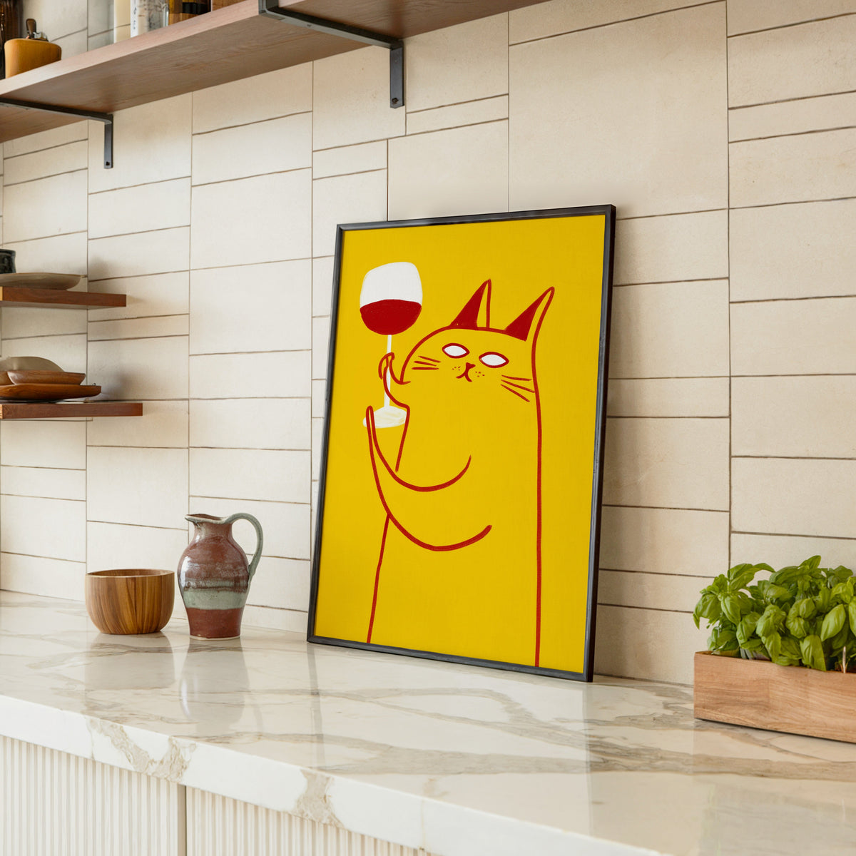 Wine Cat print in a black frame leaning on a marble counter in a tiled kitchen