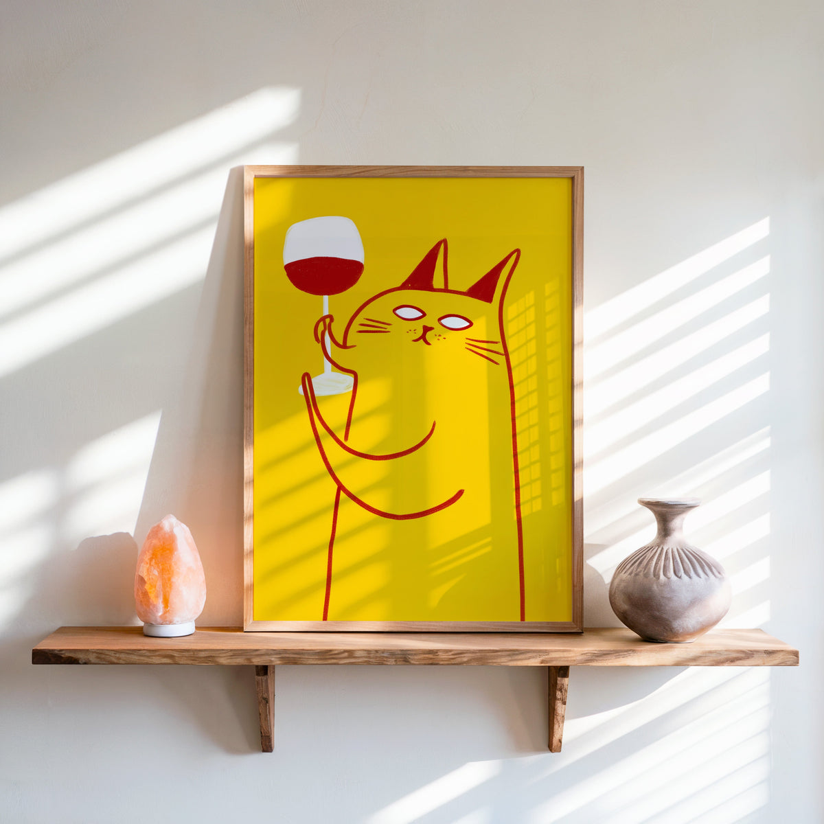 Wine Cat print in an oak frame on a live-edge shelf beside a salt lamp