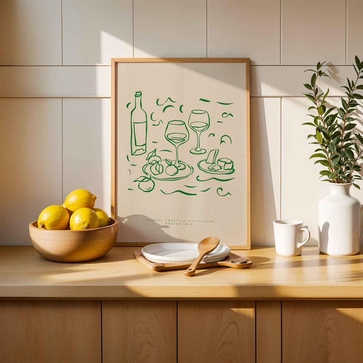 Green line wine and cheese print in a slim oak frame beside a wooden bowl of lemons
