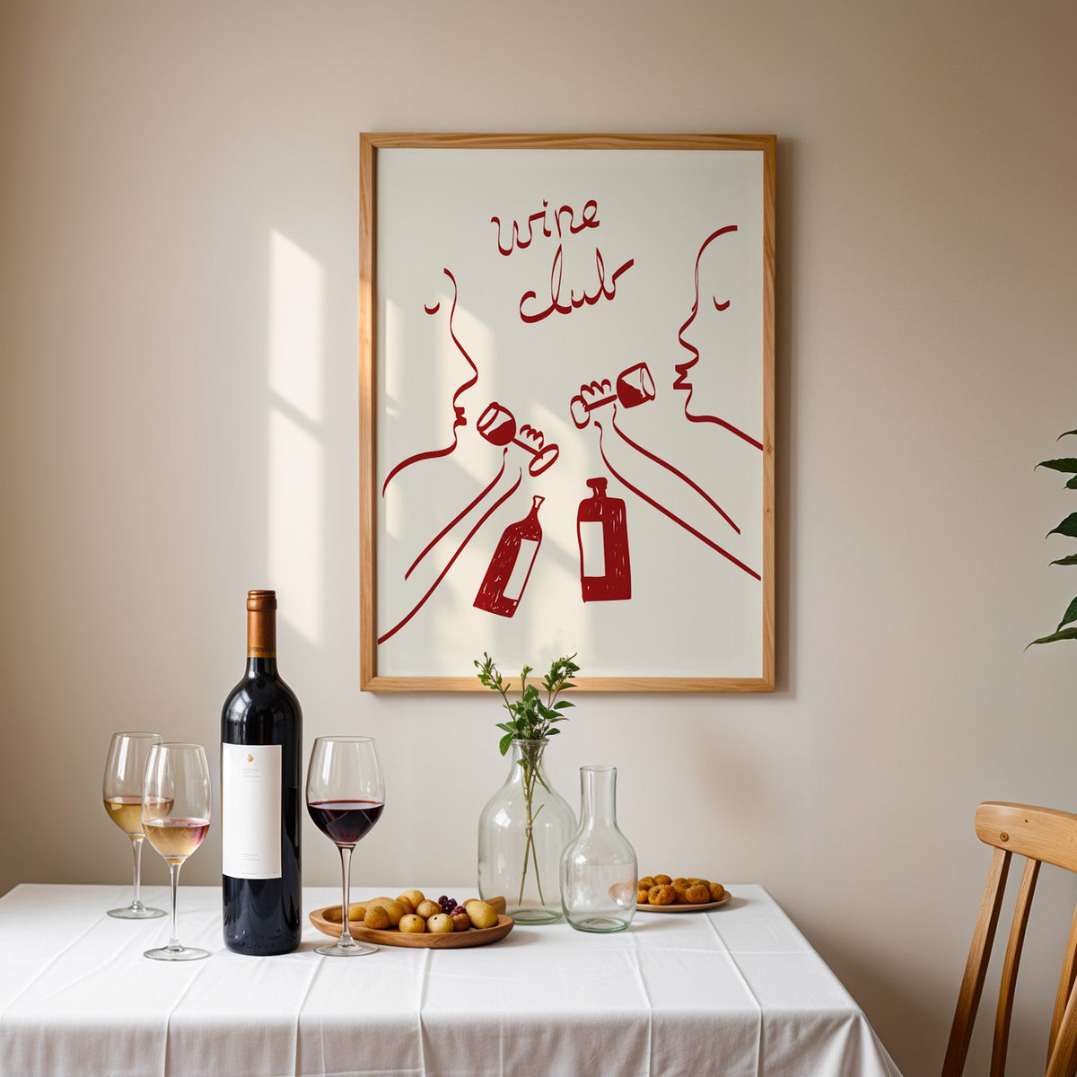 Wine club faces line art print in an oak frame above a table laid with red wine