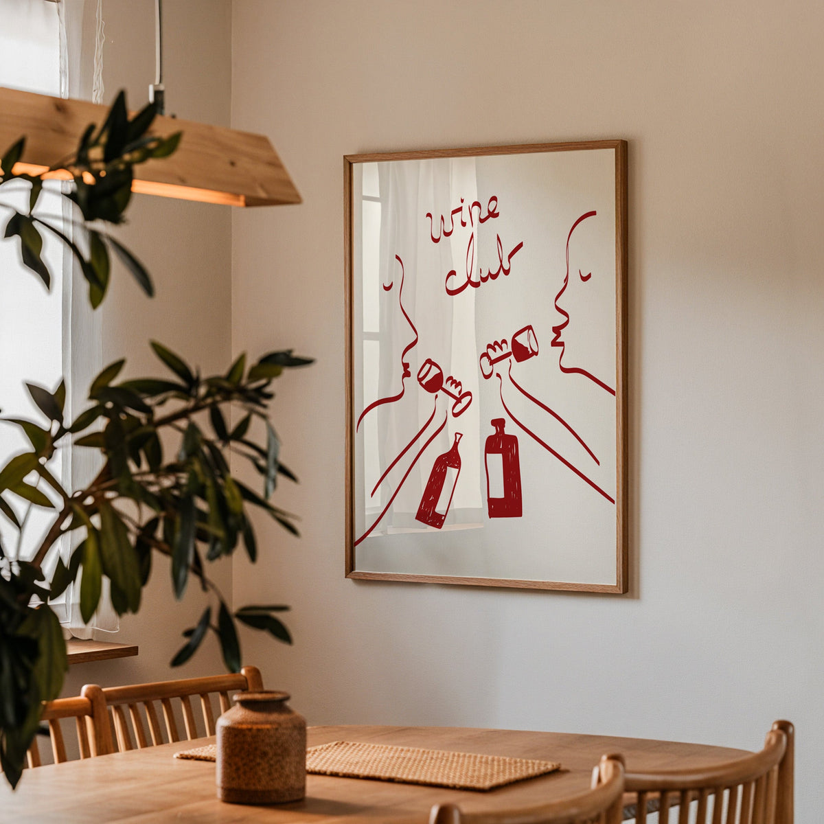 Wine club faces line art print in a walnut frame above a table by an olive tree