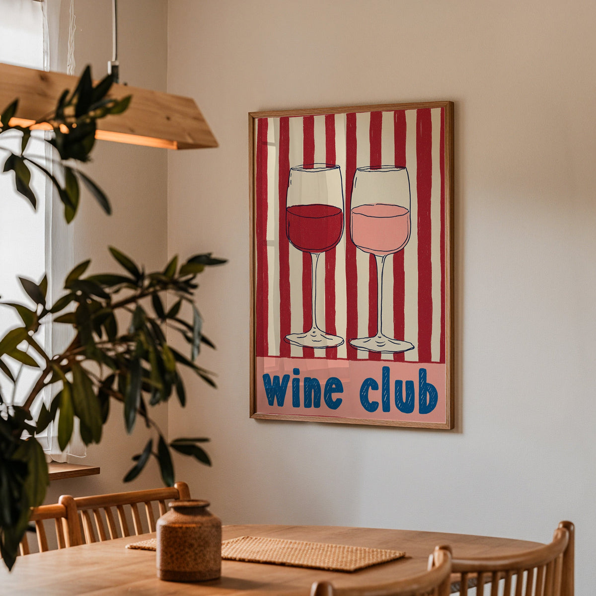 Wine Club print in a walnut frame above a dining table with olive branches