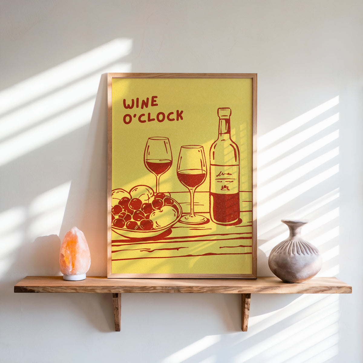 Wine O'Clock print in an oak frame on a live-edge shelf beside a salt lamp