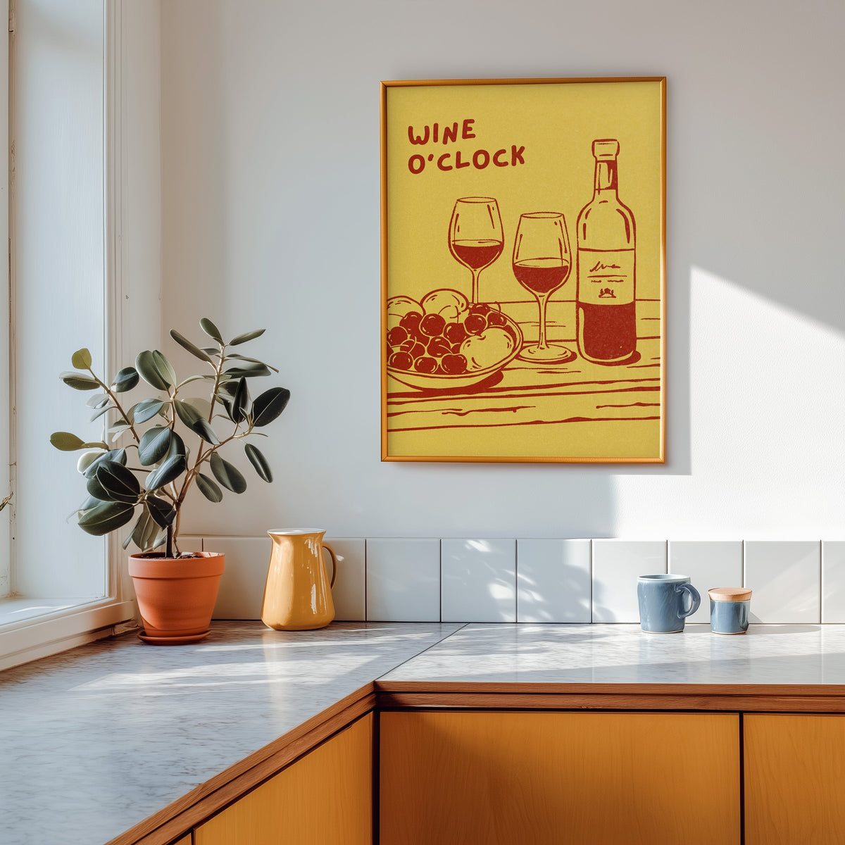 Wine O'Clock print shown in a gold frame above a marble counter in a tan kitchen