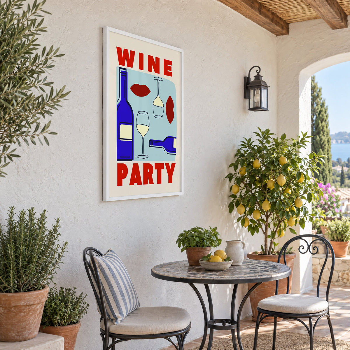 Wine Party bottles and red lips print in a white frame on a sunny patio wall beside a potted lemon tree