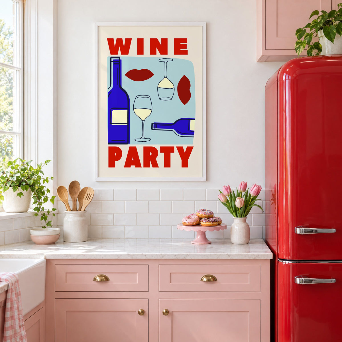 Wine Party bottles and red lips print in a white frame in a pink kitchen beside a red retro fridge