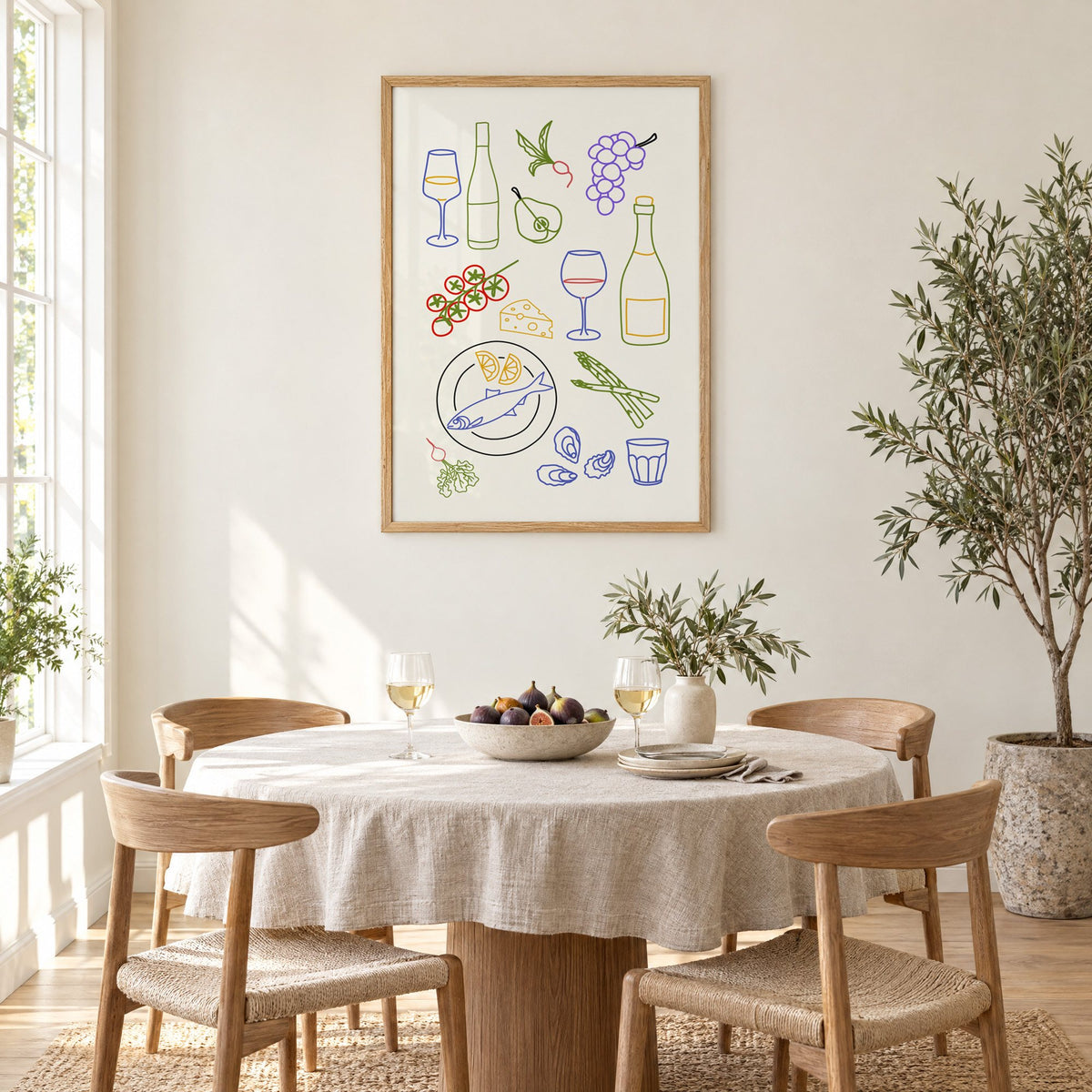 Colorful wine picnic line art print in an oak frame above a round linen-covered dining table with figs and wine