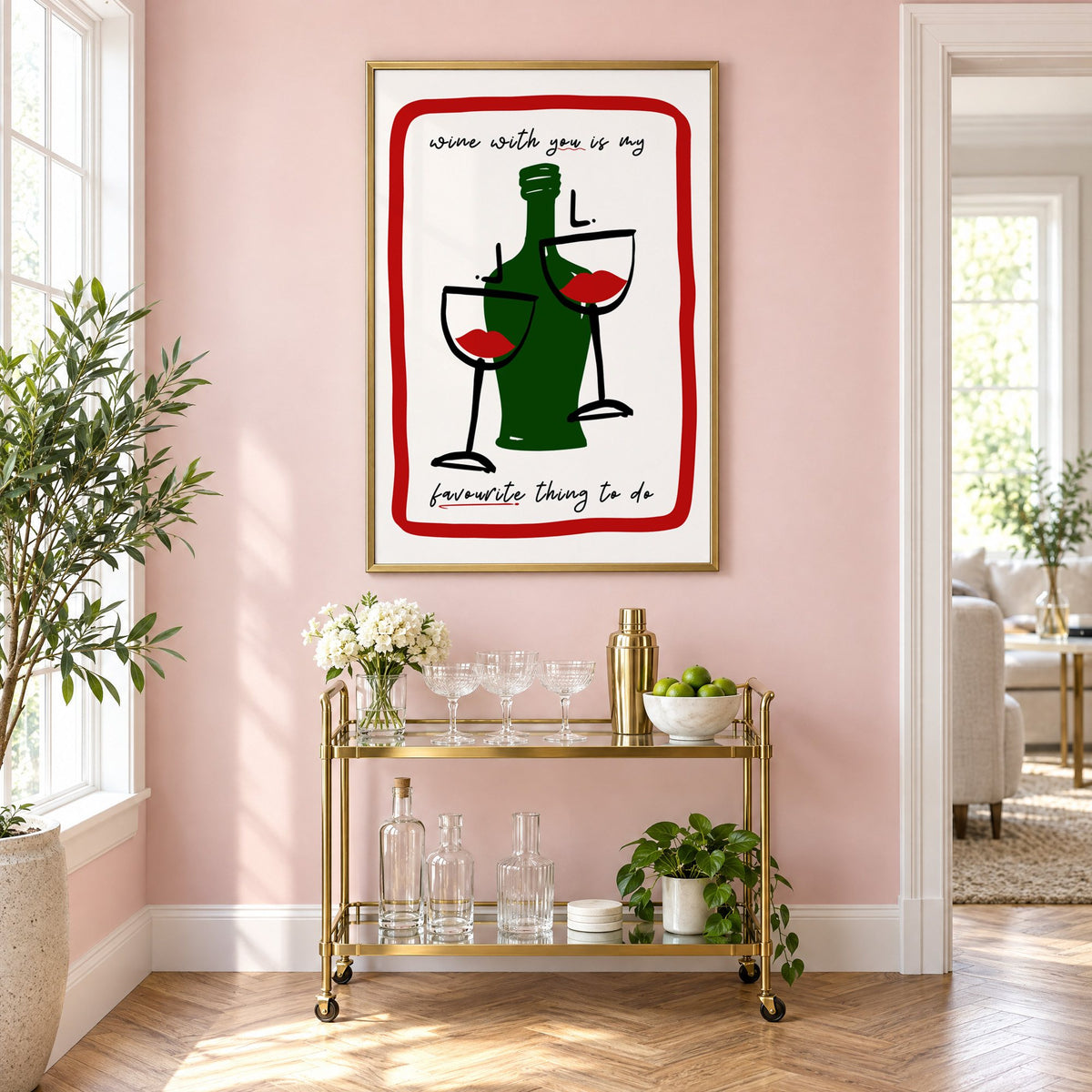 Wine with you lip glasses print in a brass frame above a gold bar cart on a blush pink wall