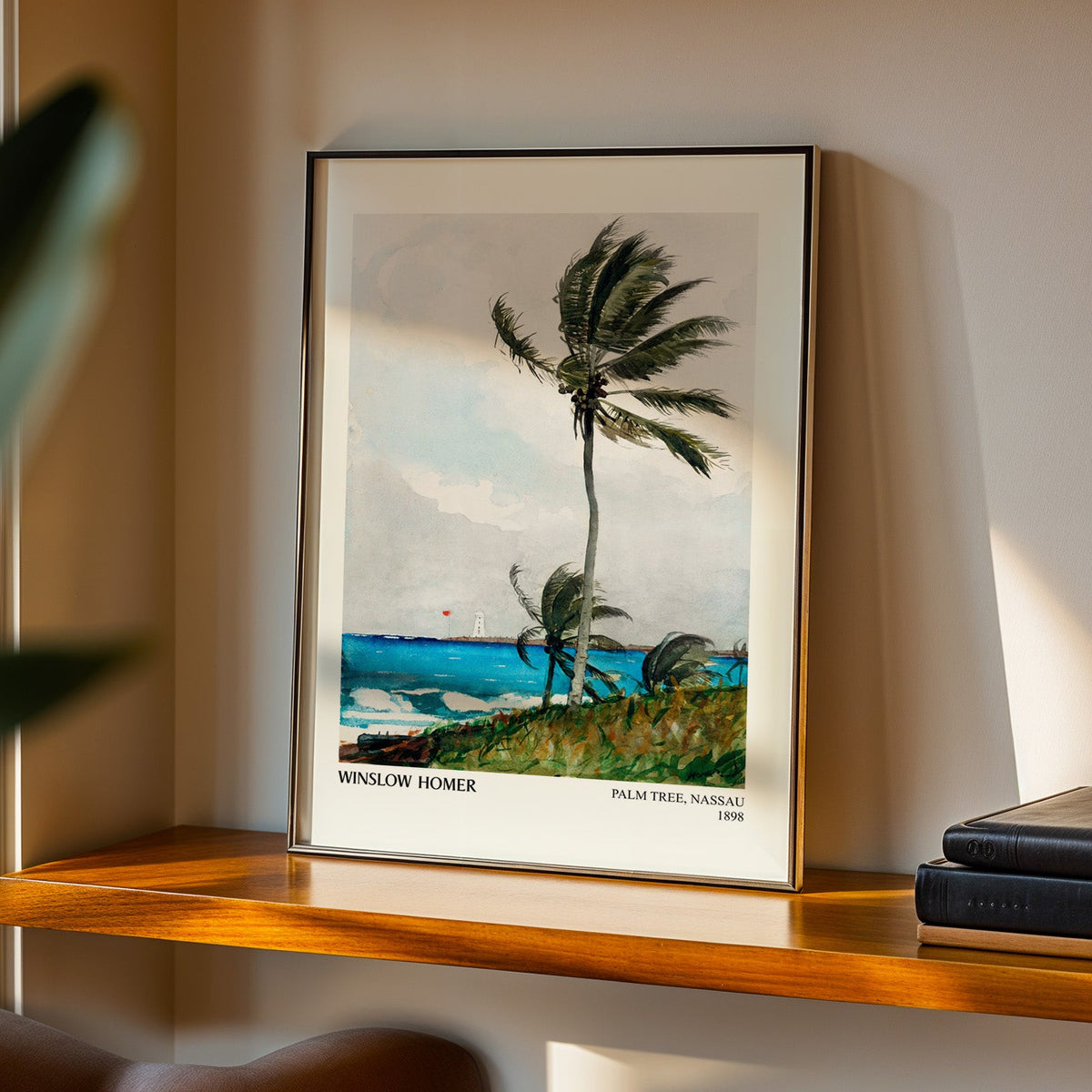 Palm Tree Nassau print in a black frame on a walnut shelf in evening light