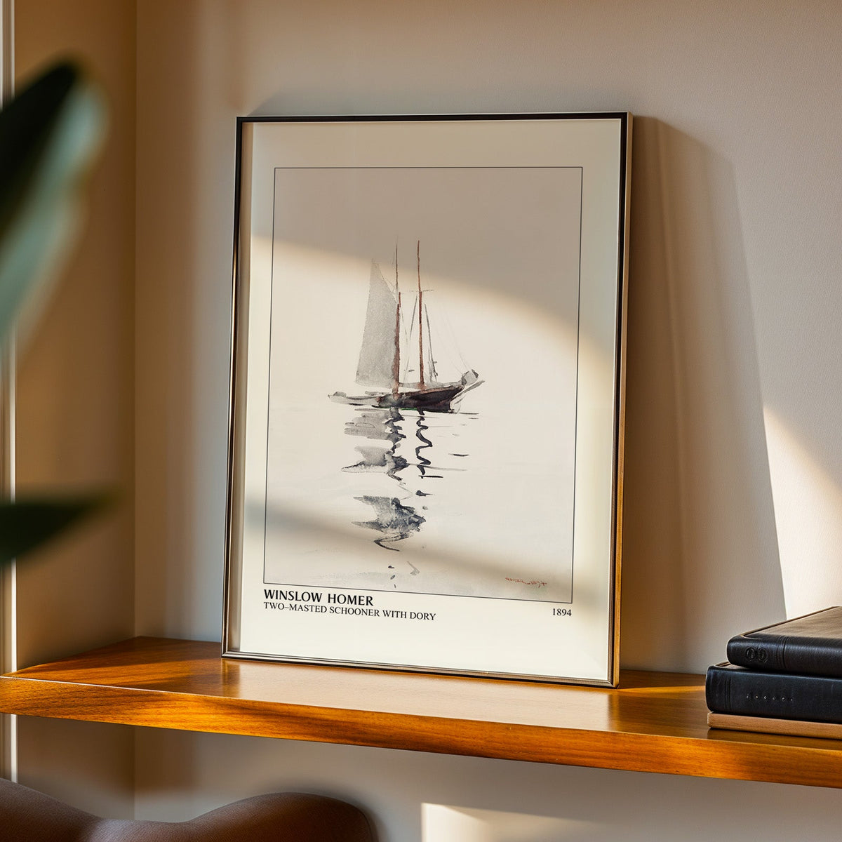Two-Masted Schooner print in a black frame on a walnut shelf in evening light