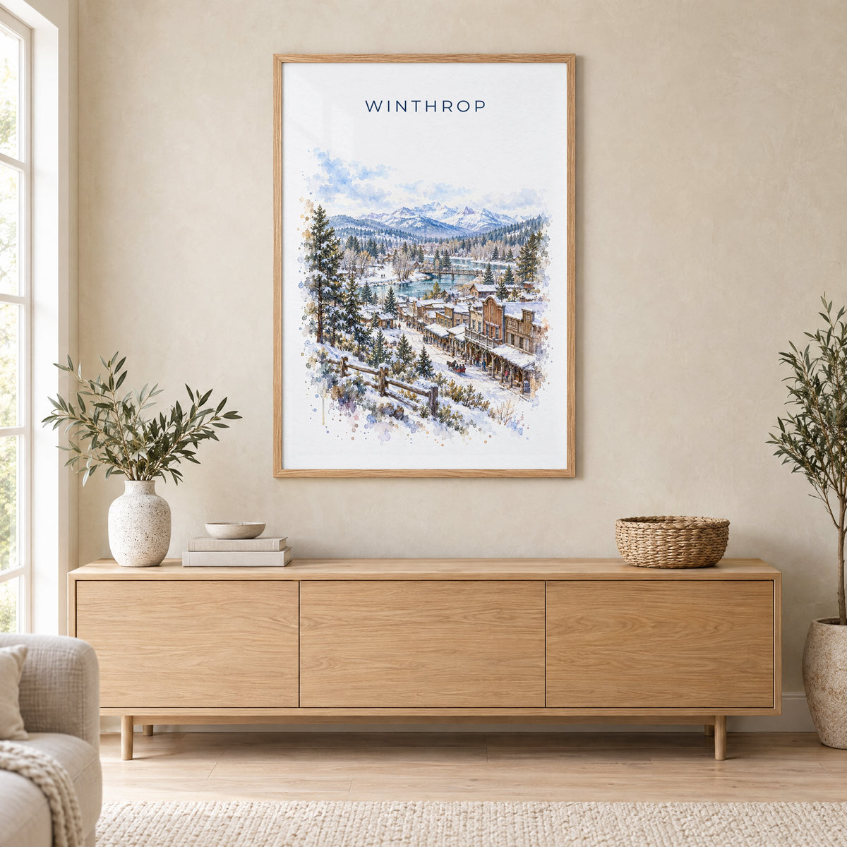 Winthrop, Washington watercolor print in an oak frame above a light wood sideboard in a Scandinavian living room