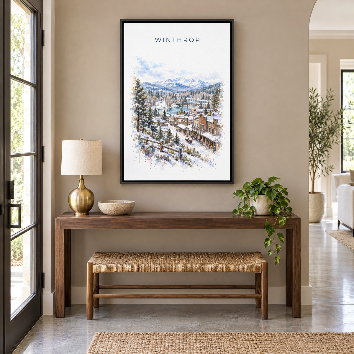 Winthrop, Washington watercolor print as a black floater canvas above a walnut console and woven bench in an entryway