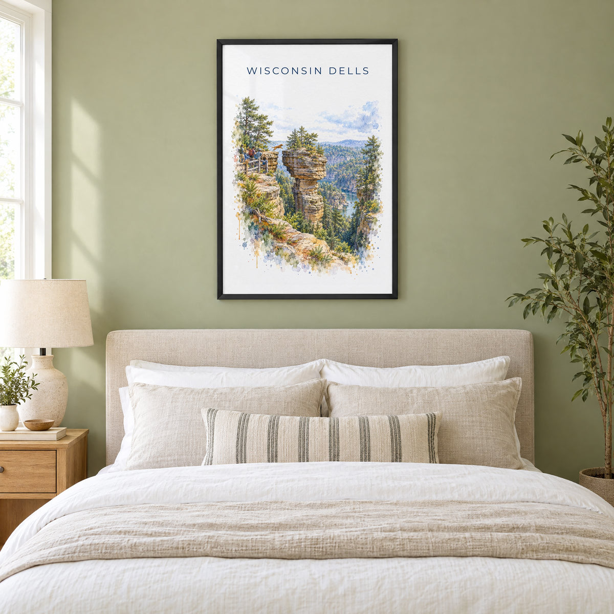 Wisconsin Dells watercolor print in a black frame above an upholstered headboard in a sage green bedroom
