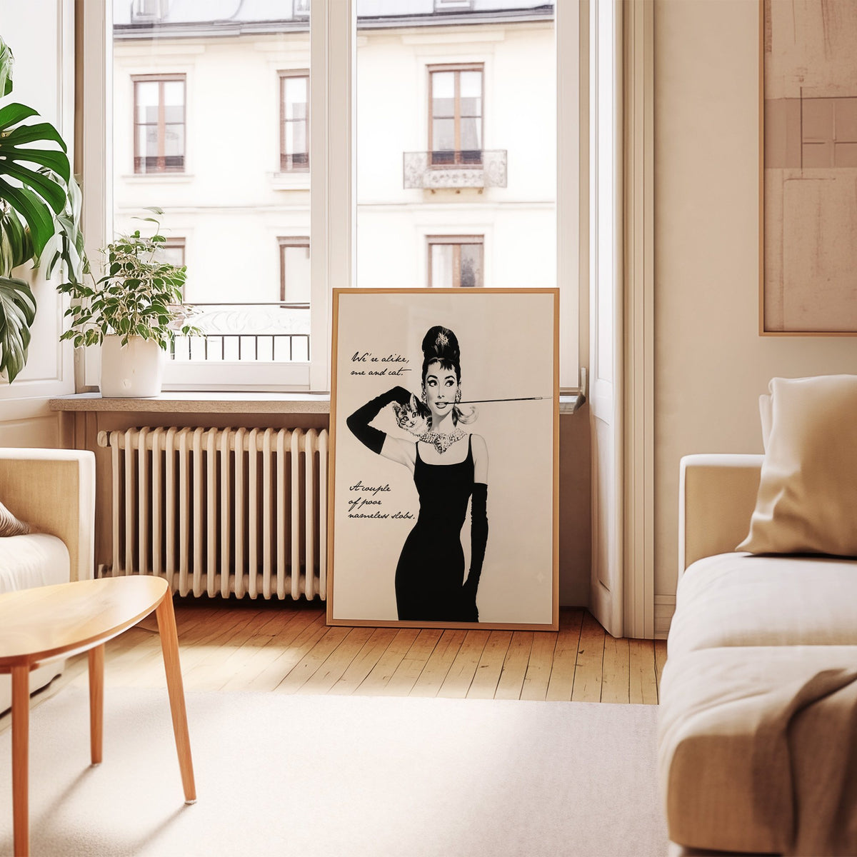 Woman in black dress with kitten and handwritten quote print in an oak frame leaning by a French window in a living room