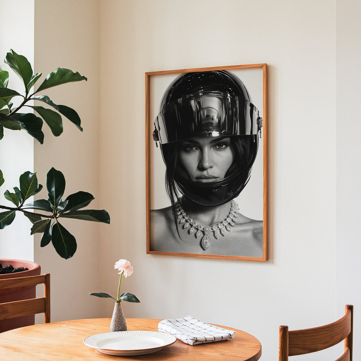 Woman in glossy black helmet and diamond necklace print in a teak frame above a round wooden dining table