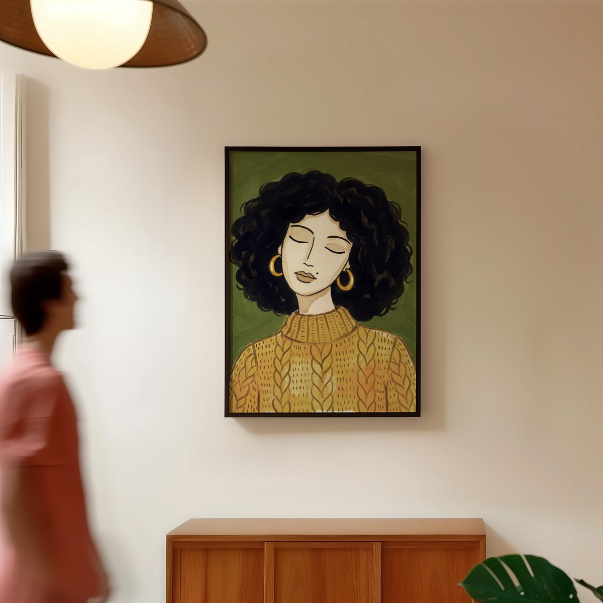 Olive and mustard portrait print in a black frame in a hallway under a rattan pendant