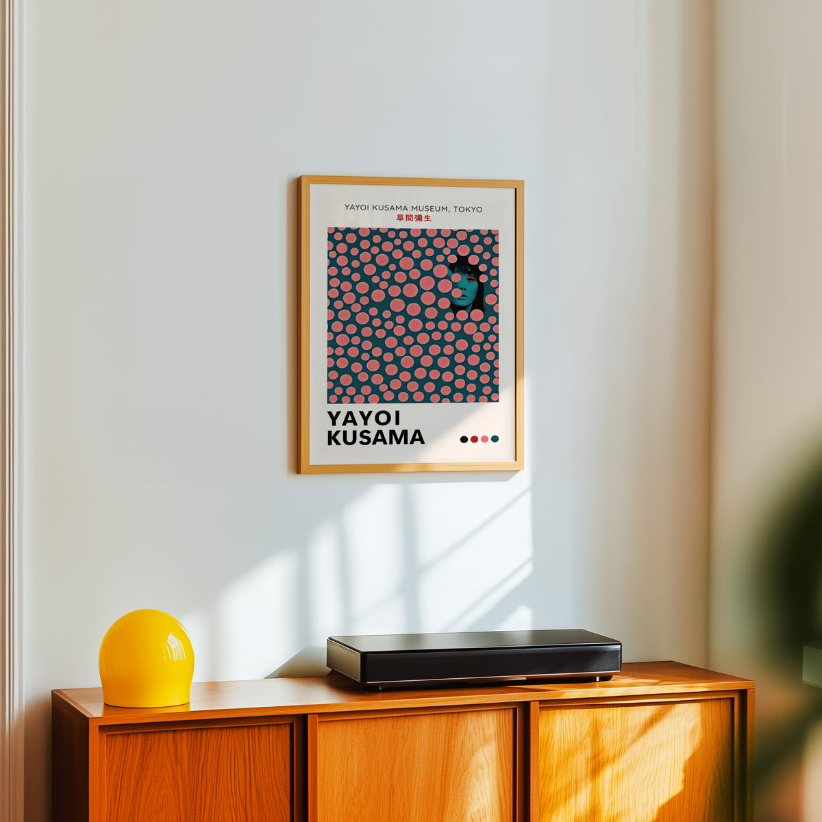 Yayoi Kusama inspired pink dots portrait print above a sideboard with a yellow lamp