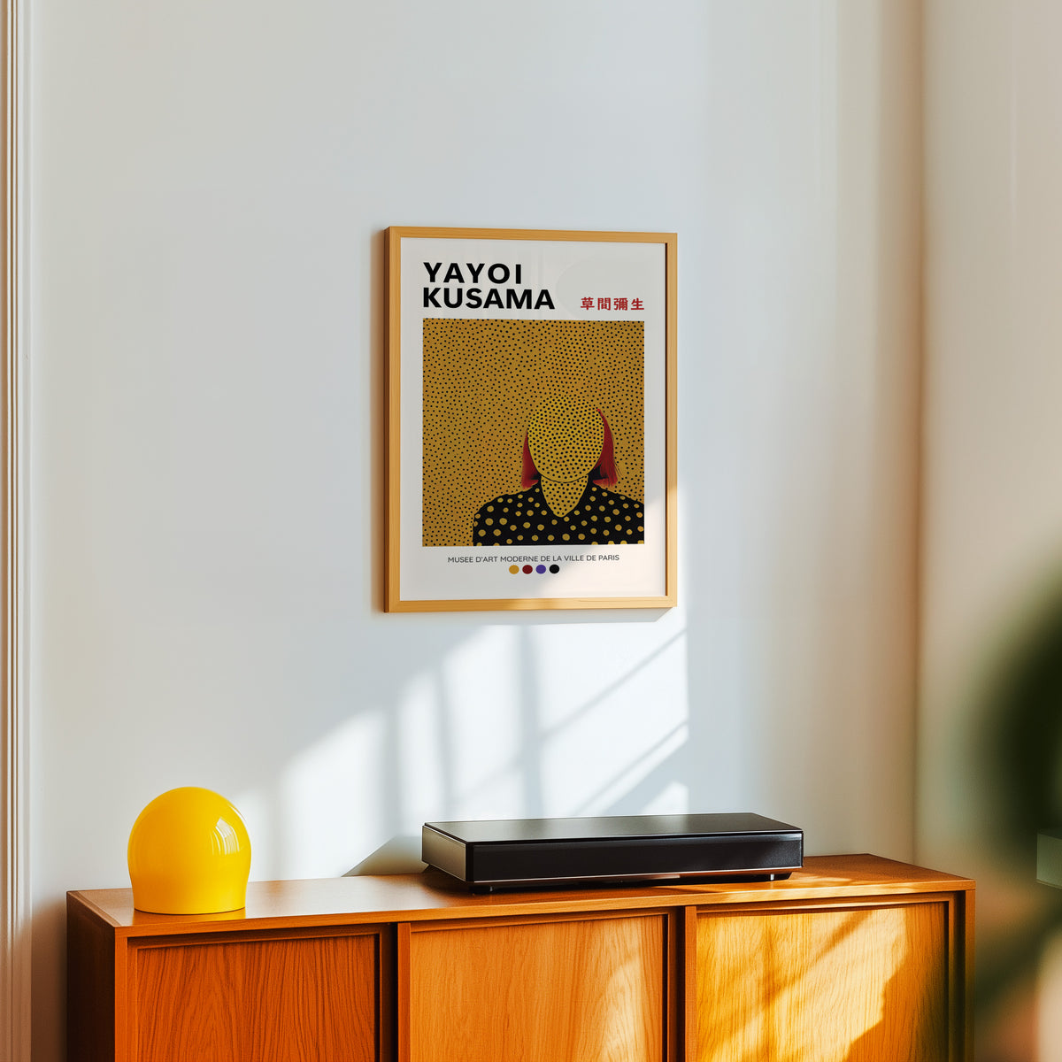 Yayoi Kusama inspired gold dots portrait print above a sideboard with a yellow lamp