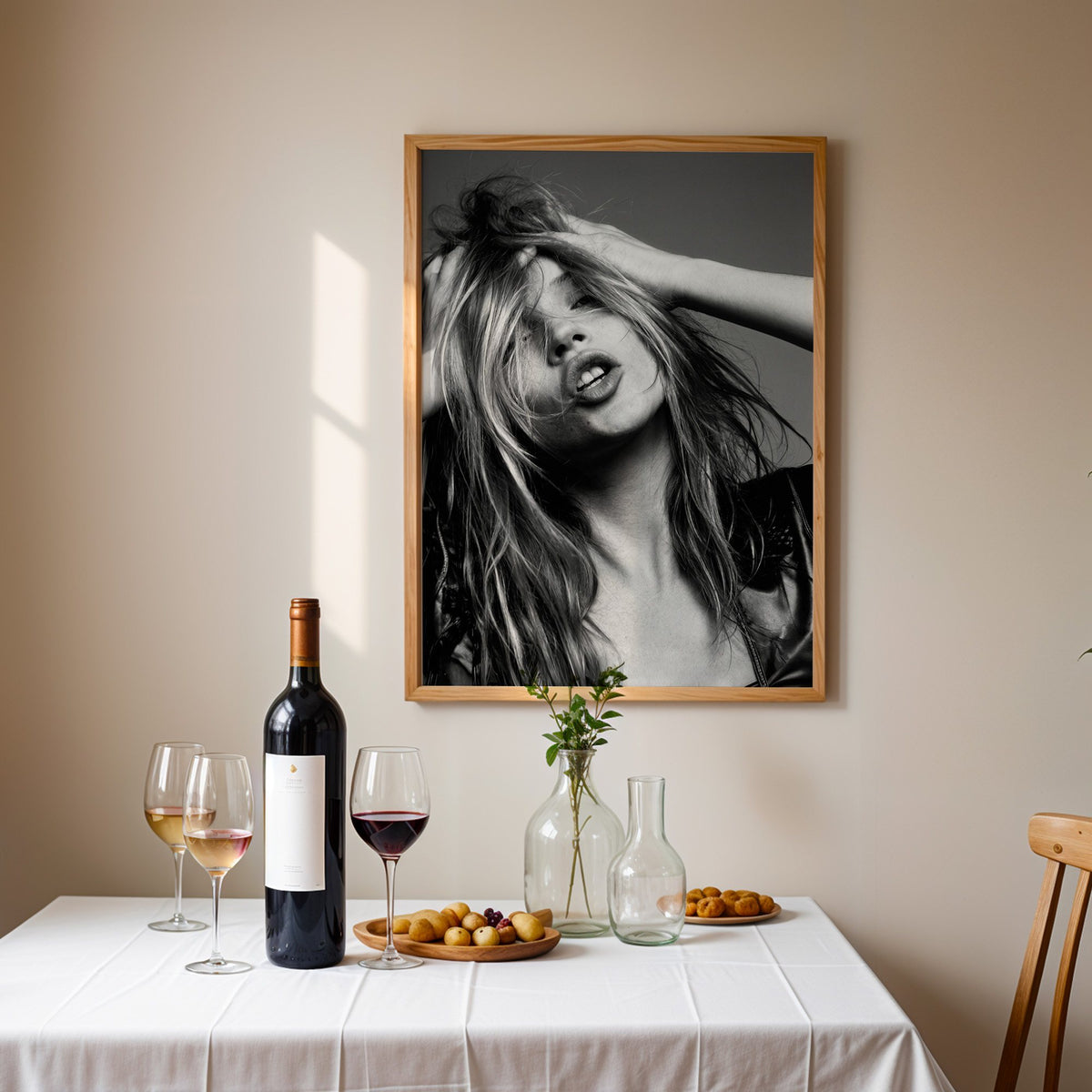 Woman pushing hands through messy hair print in an oak frame above a table set with red wine and glasses