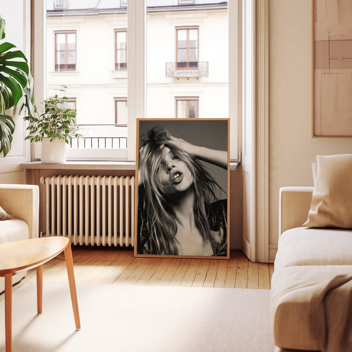 Woman pushing hands through messy hair print in an oak frame leaning by a French window in a living room
