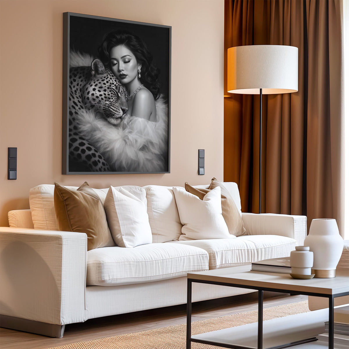 Woman leaning on leopard in fur black and white print in a black frame above a cream sofa on a blush living room wall