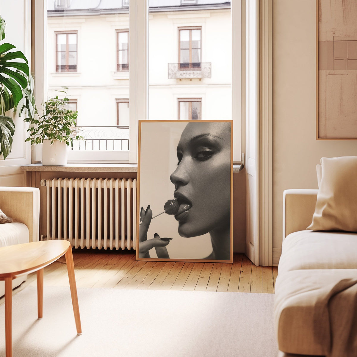 Glossy closeup with lollipop and black nails print in an oak frame leaning by a French window in a living room
