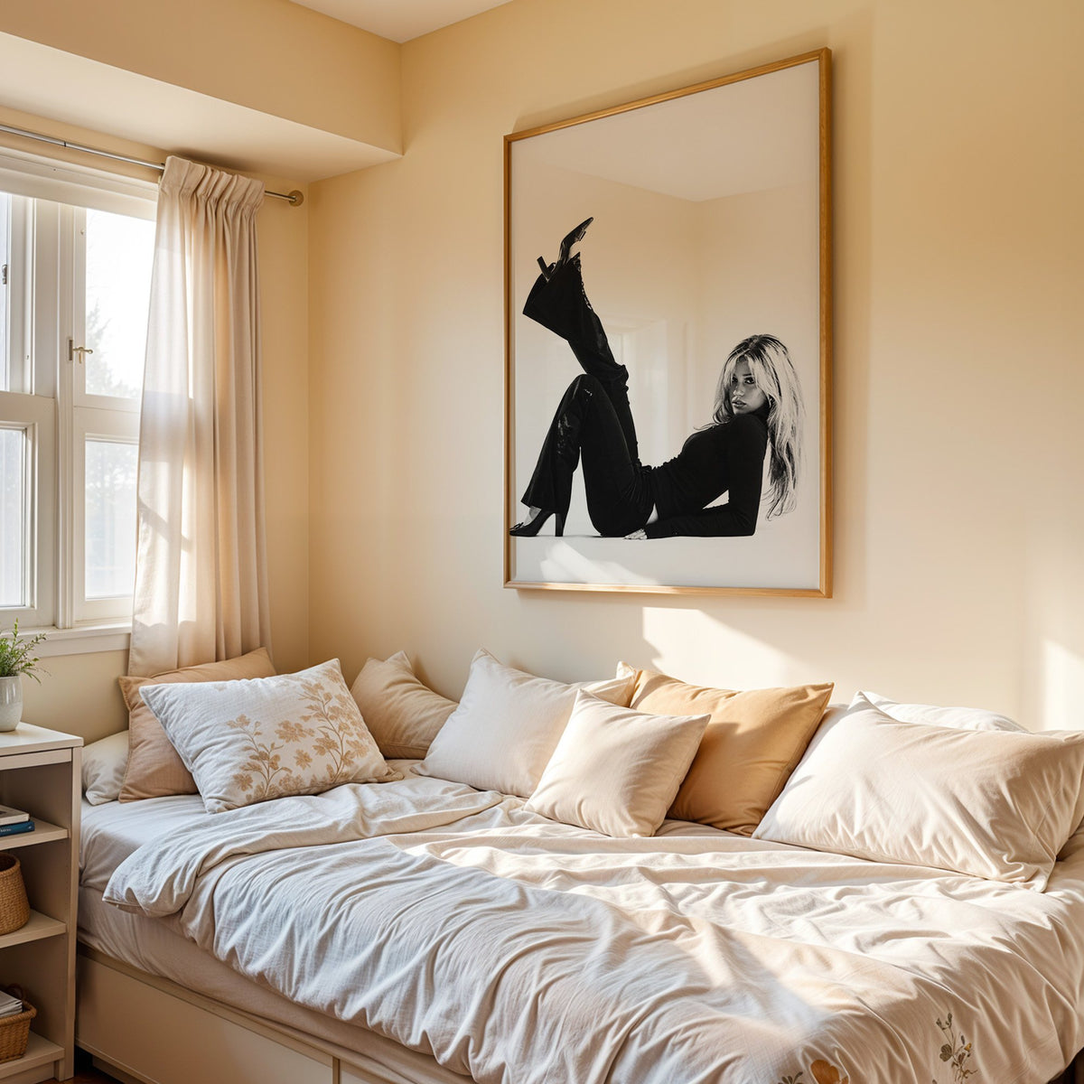 Woman in all black lying with leg raised print in an oak frame above a cream daybed in a sunny bedroom