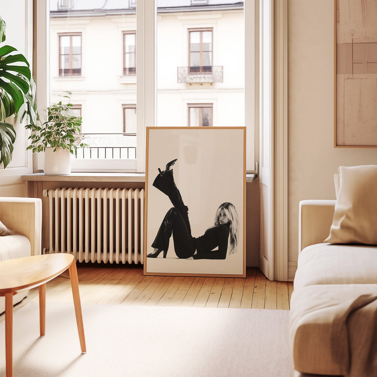 Woman in all black lying with leg raised print in an oak frame leaning by a French window in a living room