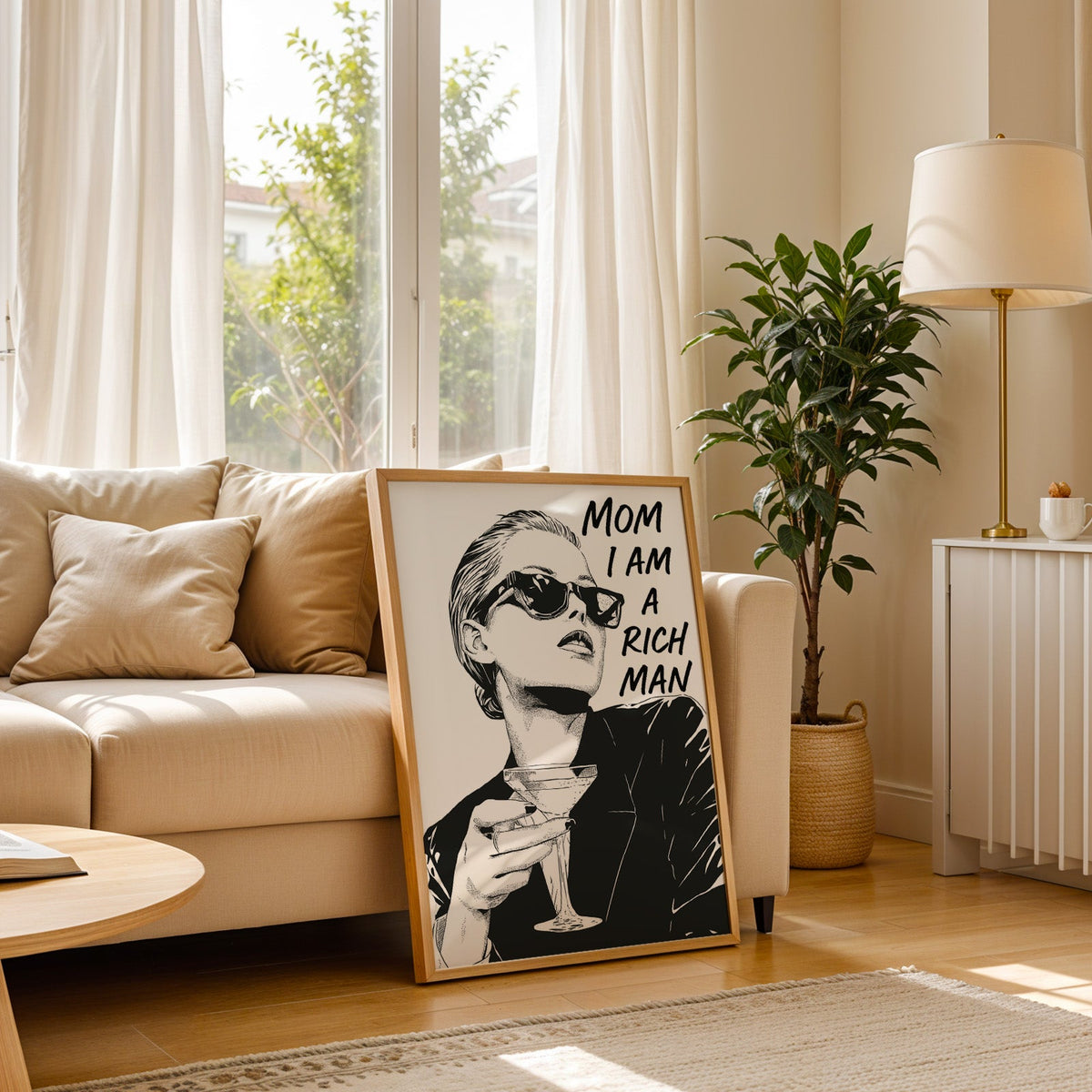 Woman in sunglasses with martini ink print in a light oak frame leaning on a cream sofa beside a floor lamp