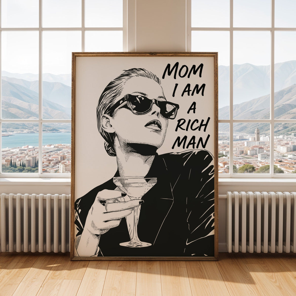 Woman in sunglasses with martini ink print shown in an antique gold frame by tall windows with a sea view