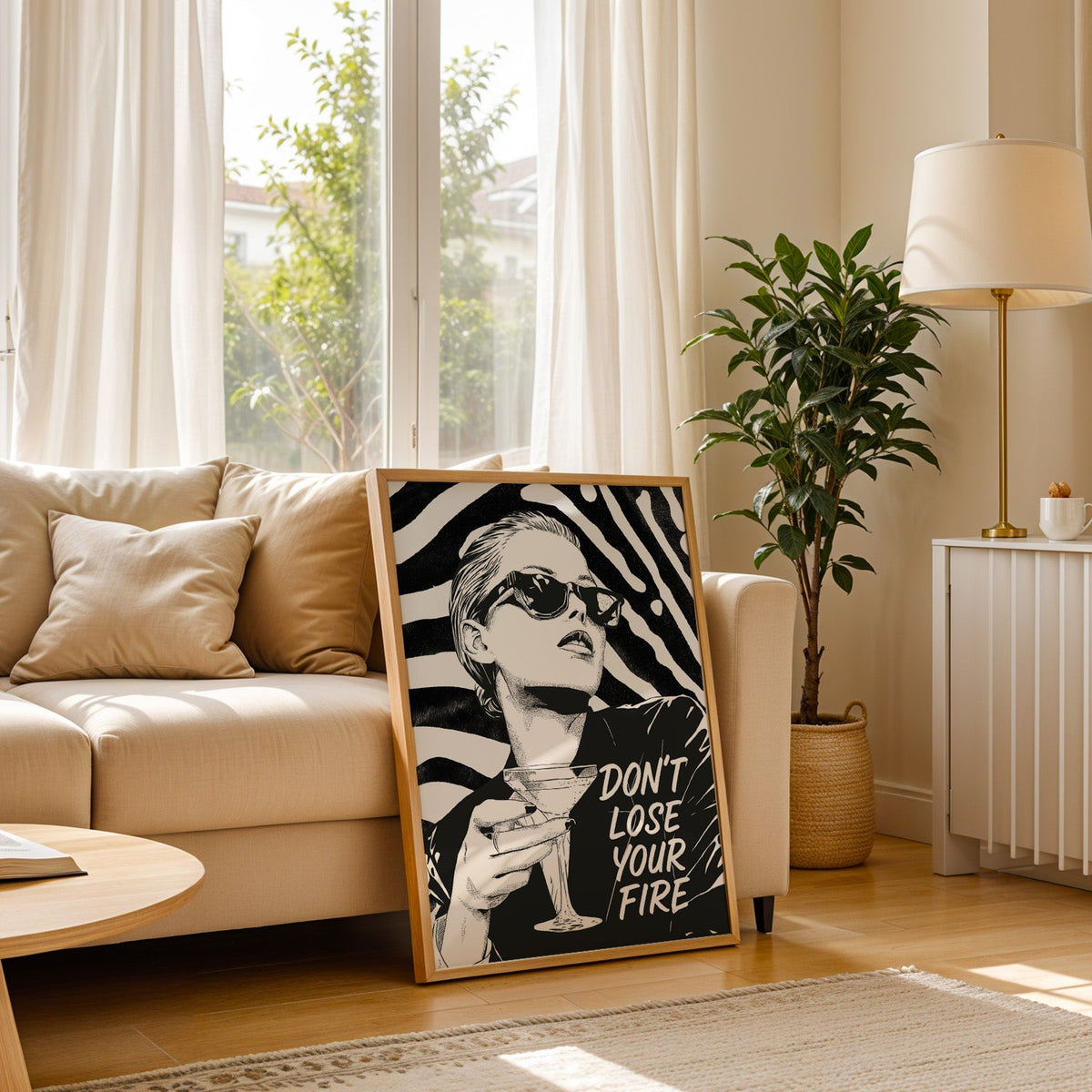 Woman with martini on zebra stripe backdrop ink print in a light oak frame leaning on a cream sofa beside a floor lamp