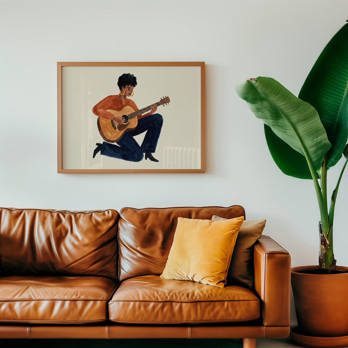 Acoustic guitar portrait print in an oak frame above a cognac leather sofa
