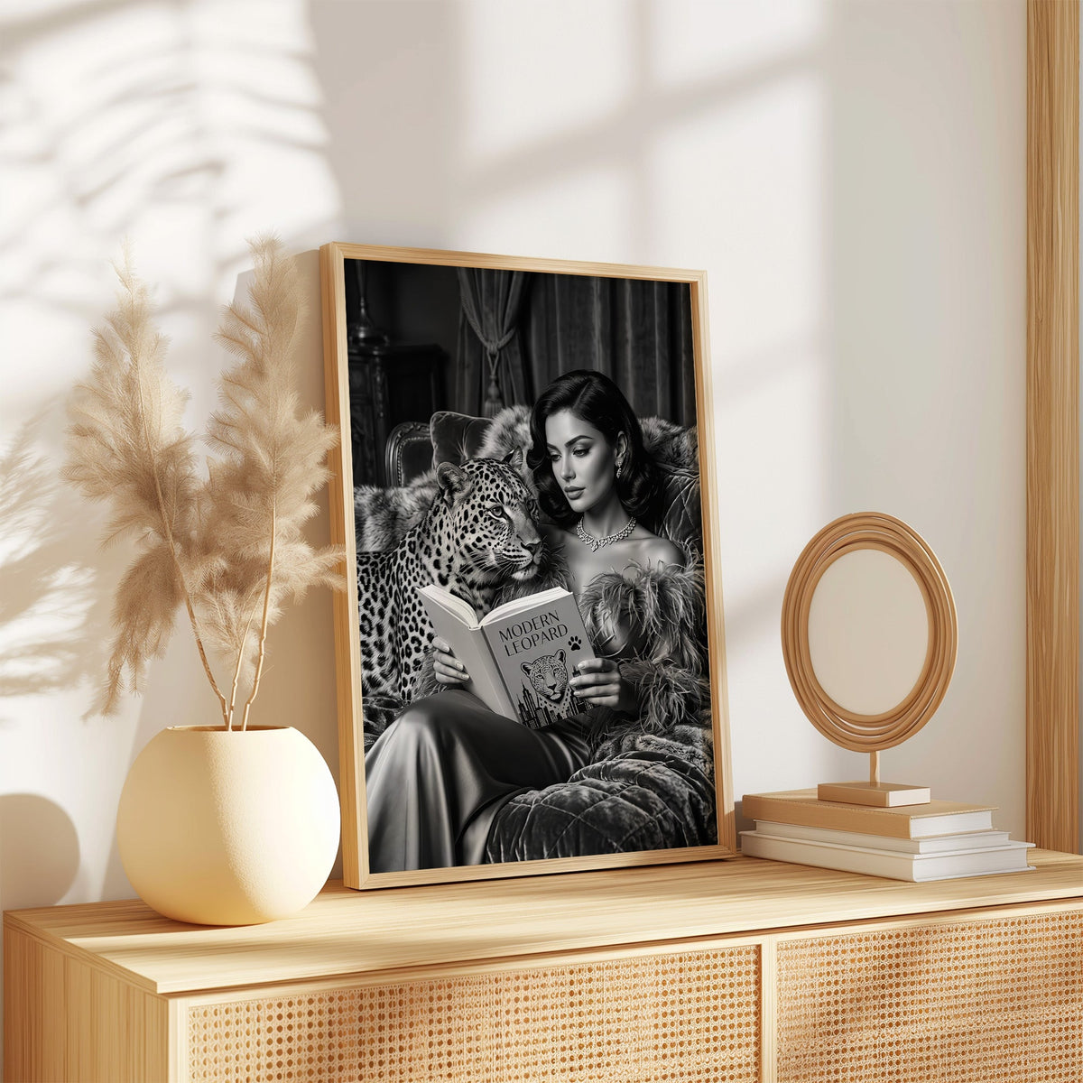 Woman reading book on velvet sofa with leopard print in an oak frame on a rattan sideboard beside pampas grass