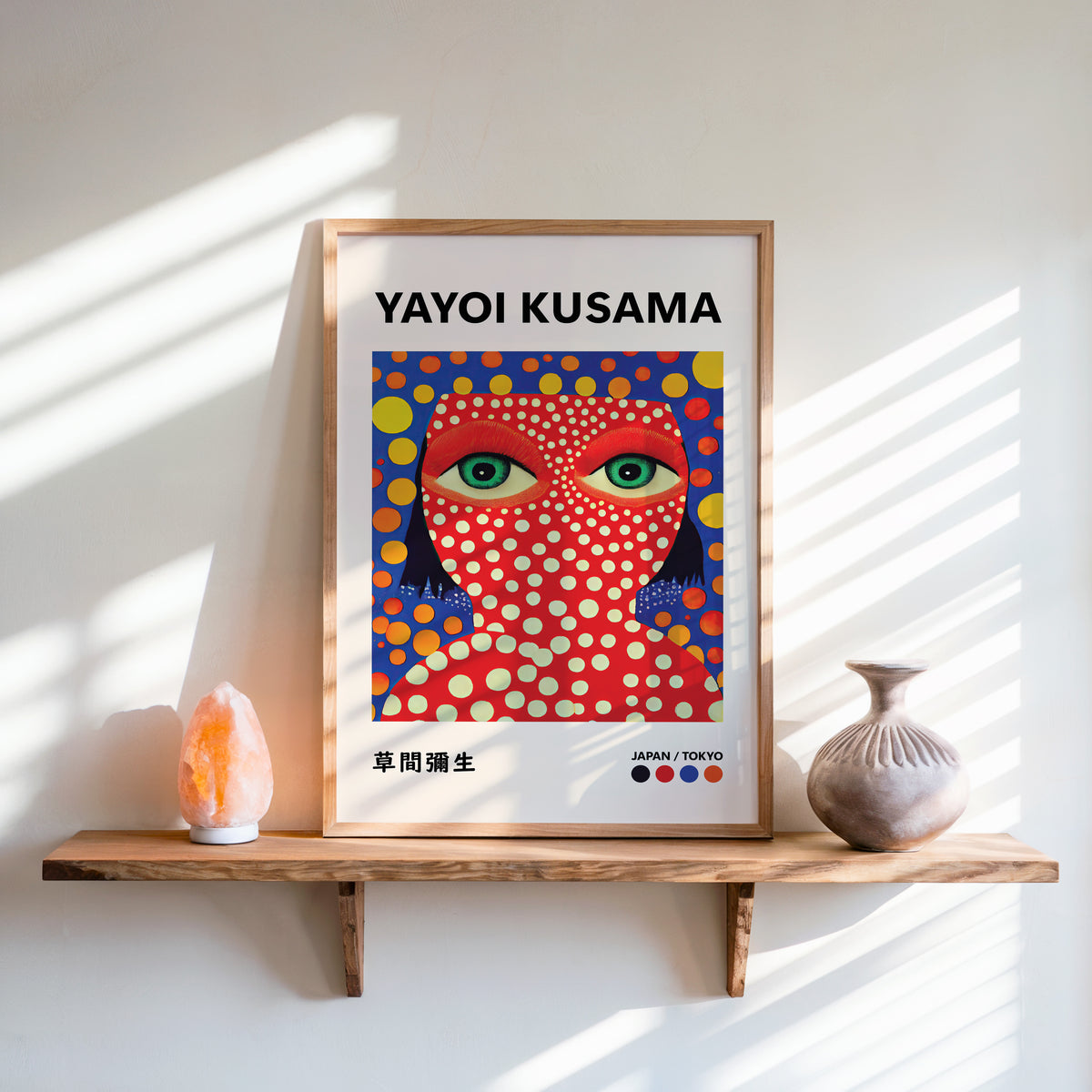 Yayoi Kusama inspired red face green eyes print above a shelf with a salt lamp