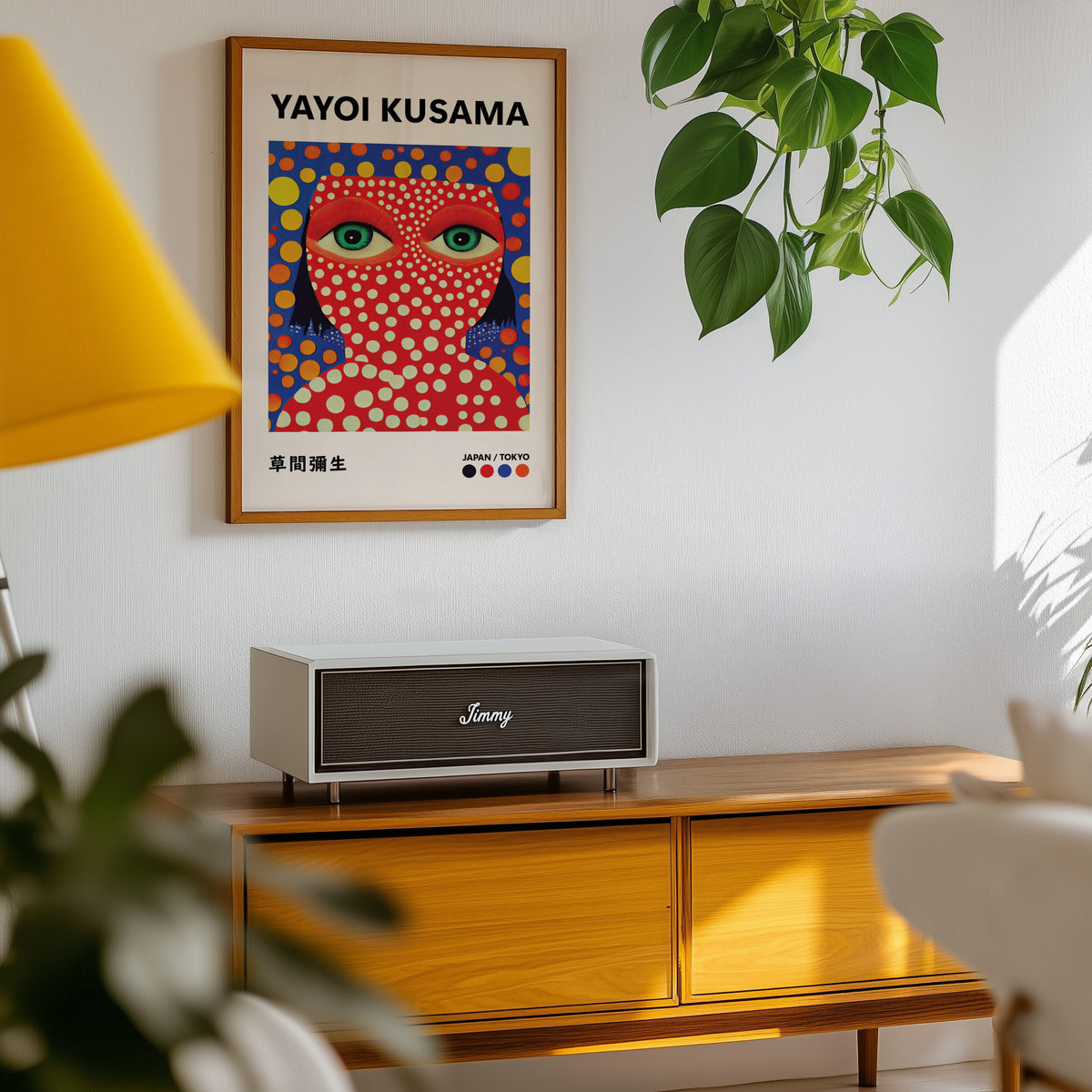 Yayoi Kusama inspired red face green eyes print above a sideboard with a plant