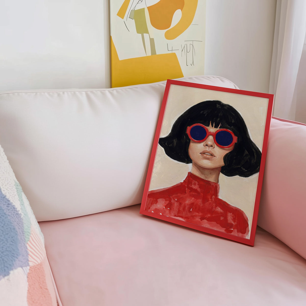 Red turtleneck portrait print shown in a red frame leaning on a blush pink sofa