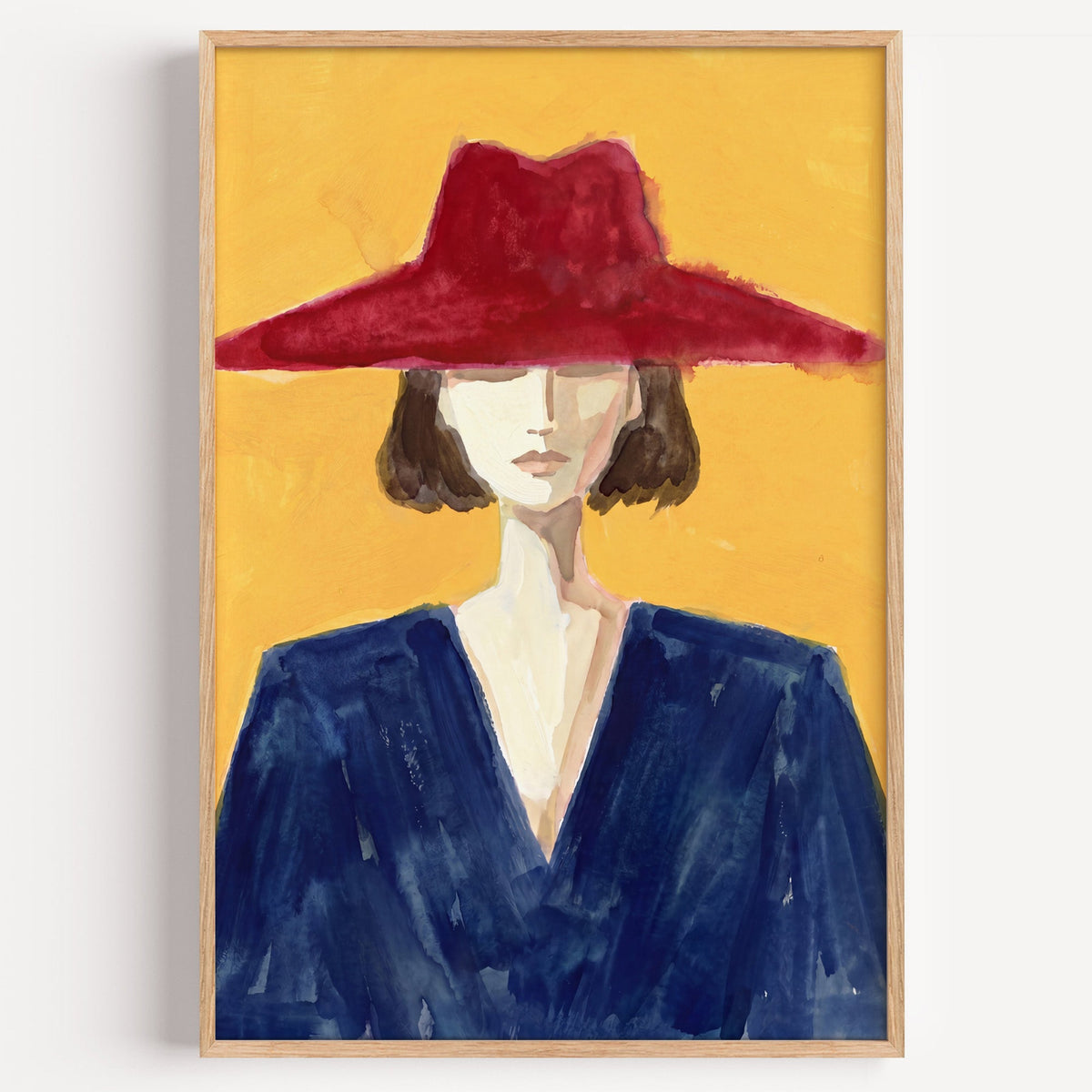 Woman in red wide brim hat print in a light oak frame on a plain white wall
