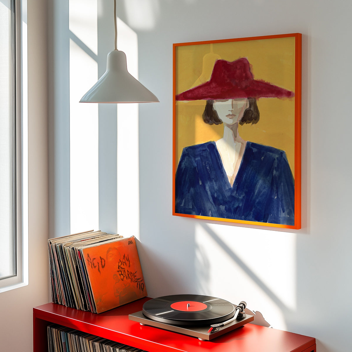 Wine red hat portrait print shown in an orange frame above a red record cabinet and turntable