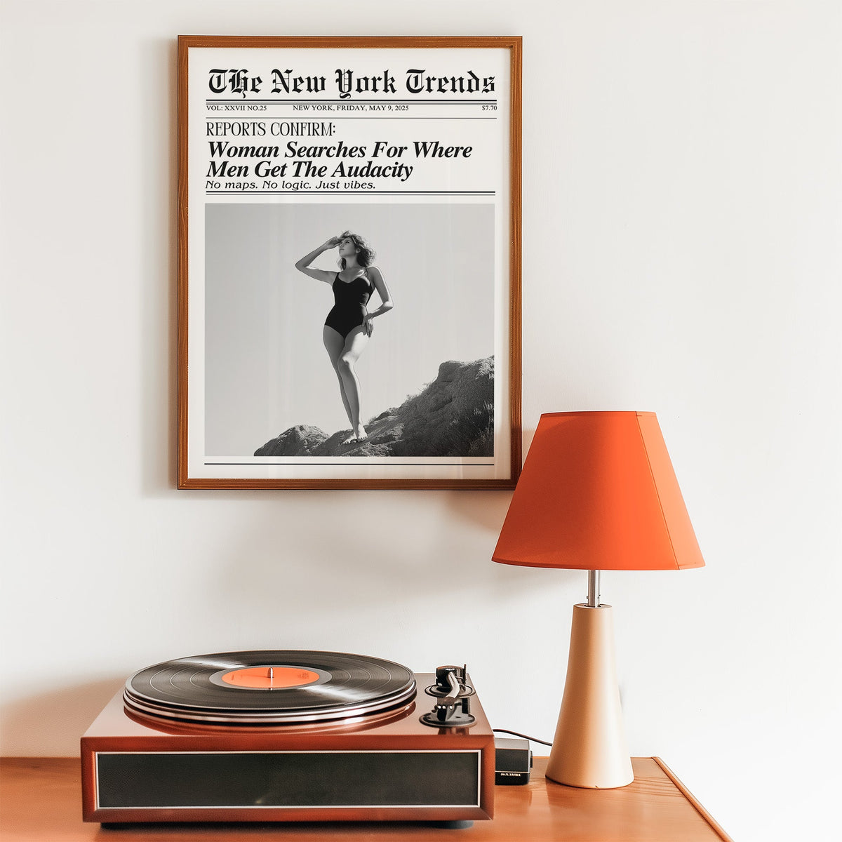 Woman on rocks shading her eyes mock newspaper print in a walnut frame above a record player and orange lamp