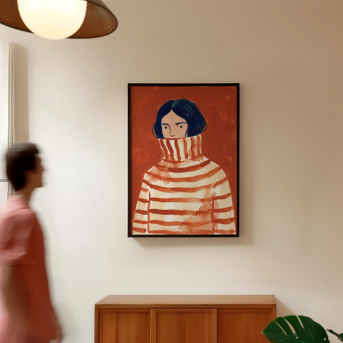 Striped sweater portrait print in a black frame in a hallway under a rattan pendant